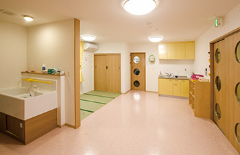 くくる保育園でこともたちが過ごすお部屋。ピンクの床に黄色い棚のかわいらしいお部屋。